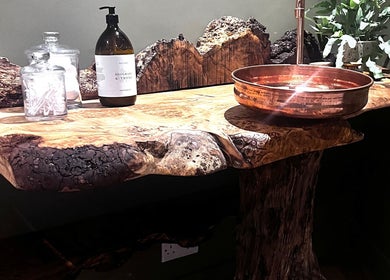 Unique rustic vanity at Fig Tree Cabin, Box, England, GB, featuring a wooden countertop and copper sink.