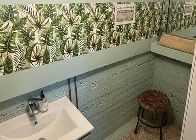 Chic washroom at Natural Edge Beulah Therapy in Devonport, Tasmania, AU with tropical leaf wallpaper.