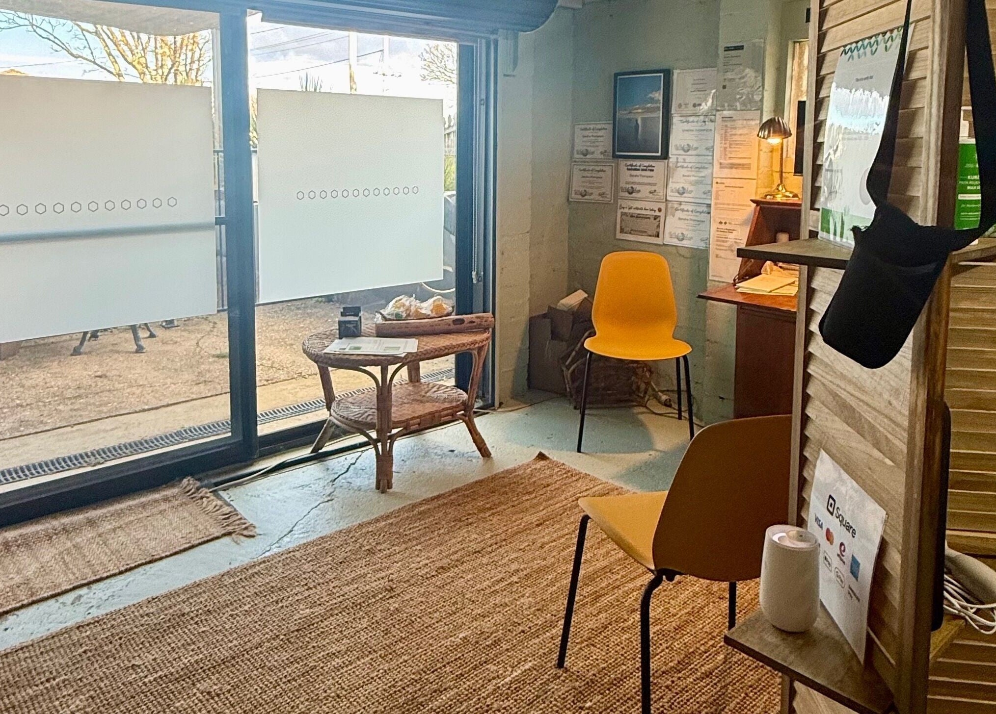 Sunlit interior of Natural Edge Beulah Therapy in Devonport, Tasmania, AU, featuring cozy seating and a woven rug.
