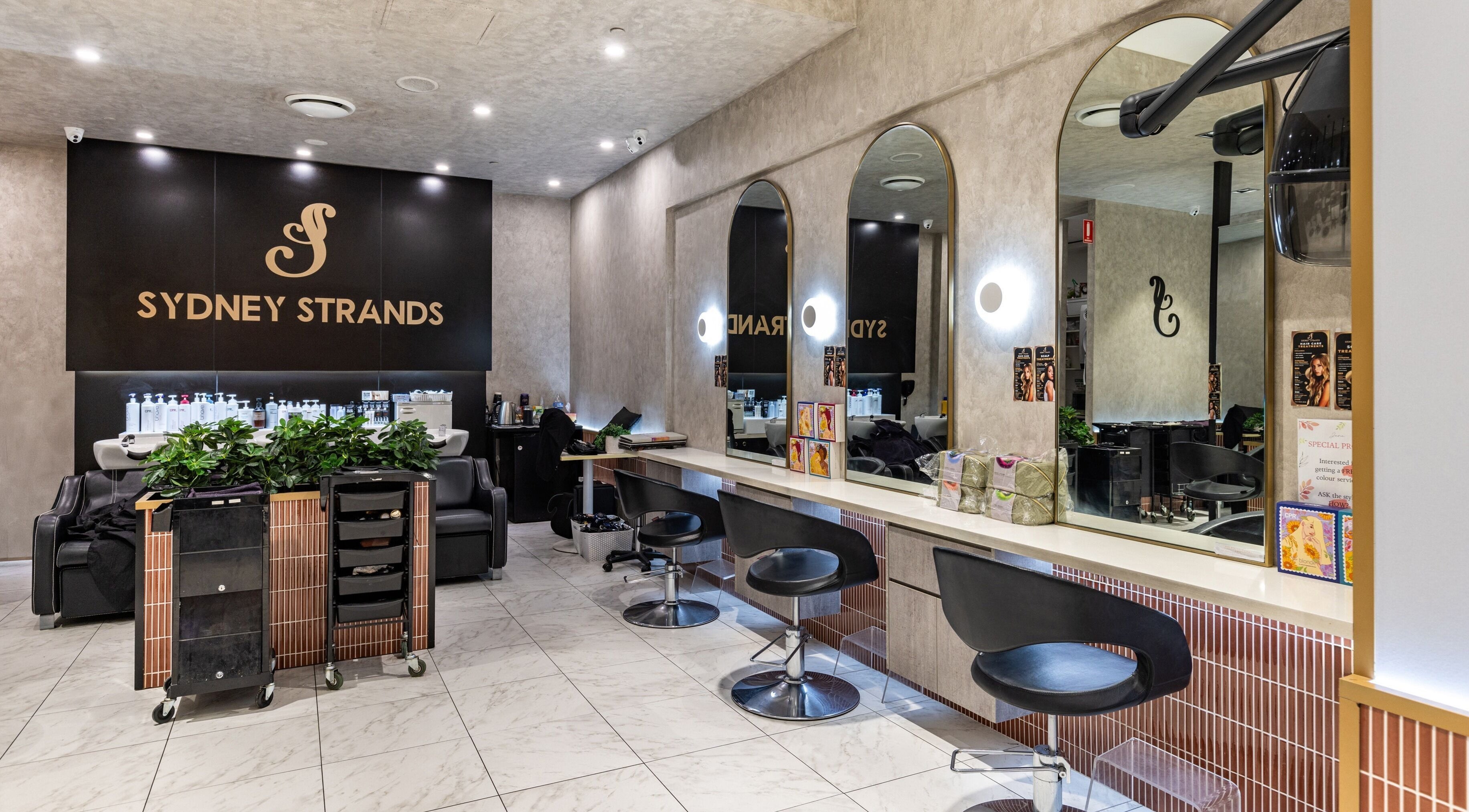 Interior of Sydney Strands salon on Kingsway, Miranda NSW, AU showcasing chic modern seating and mirrors.