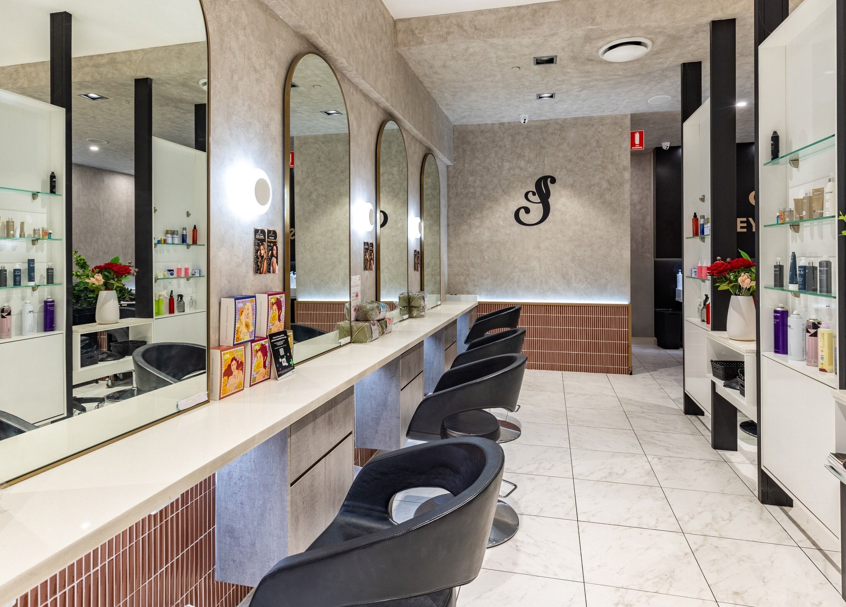 Elegant salon interior of Sydney Strands, Kingsway, Miranda NSW, AU, showcasing stylish mirrors and seating.