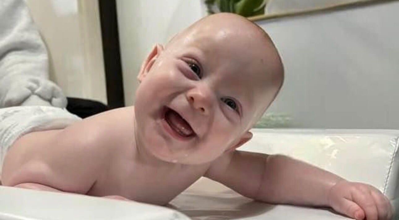 Smiling baby during a massage session at Daydreams Infant Massage, Dianella, Western Australia, AU.