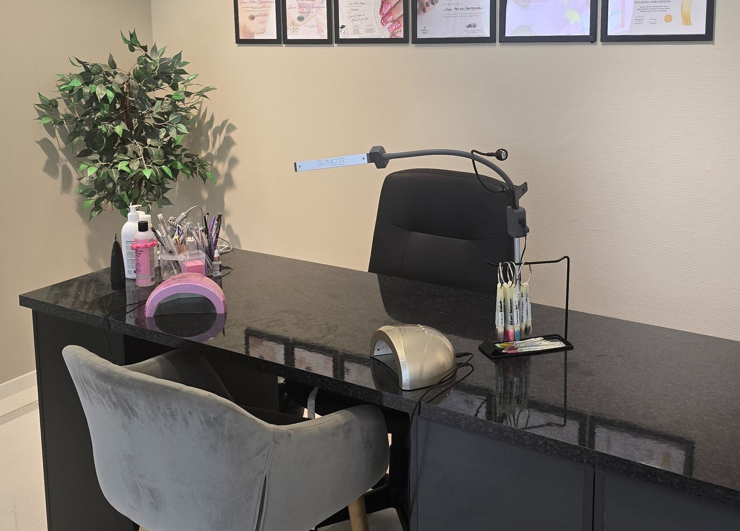 XO Beauty & Academy AS i Sarpsborg, Østfold, elegant neglebord med sertifikater på veggen.