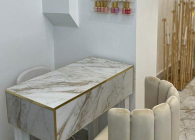 Elegant marble nail station at Athena Mortlake in London, England, GB, showcasing chic design and nail polish display.