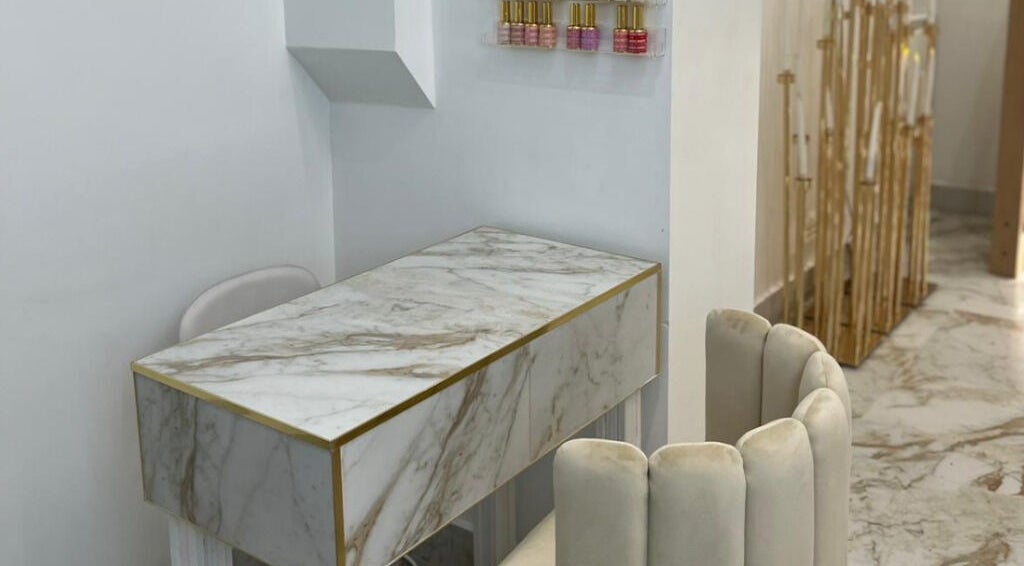 Elegant marble nail station at Athena Mortlake in London, England, GB, showcasing chic design and nail polish display.