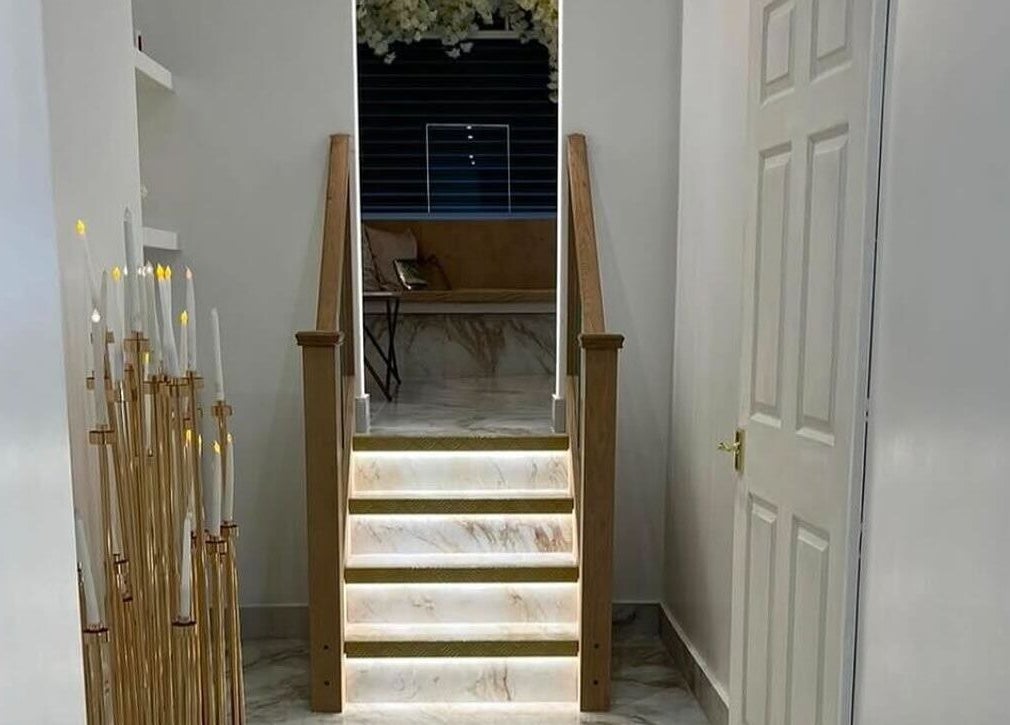 Sophisticated staircase at Athena Mortlake, London, England, GB, accented with candles and soft lighting.