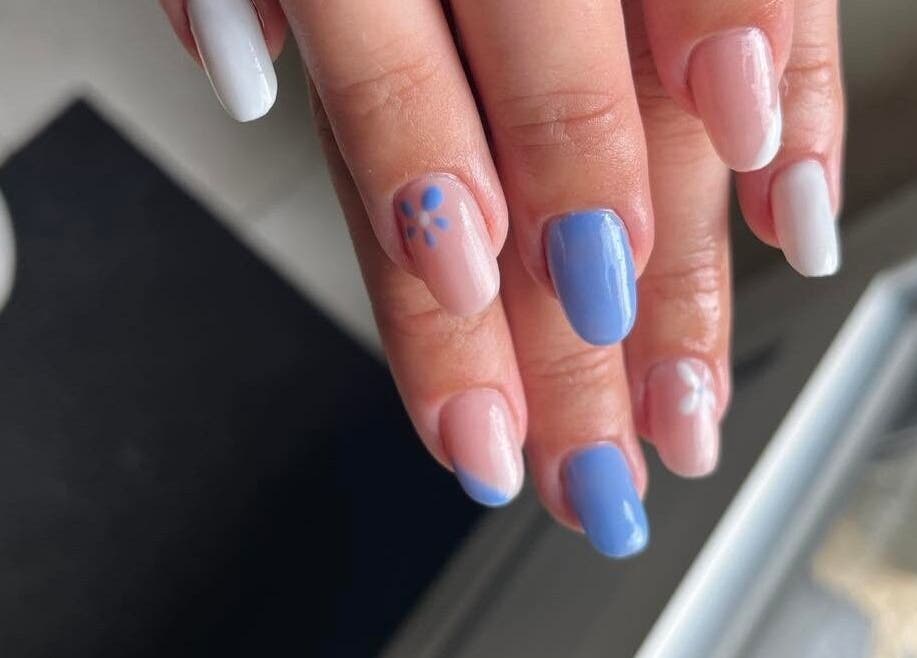 Une manucure pastel à Les Douces Heures De Marie, Ruffiac, Bretagne, FR avec des motifs floraux blancs et bleus.