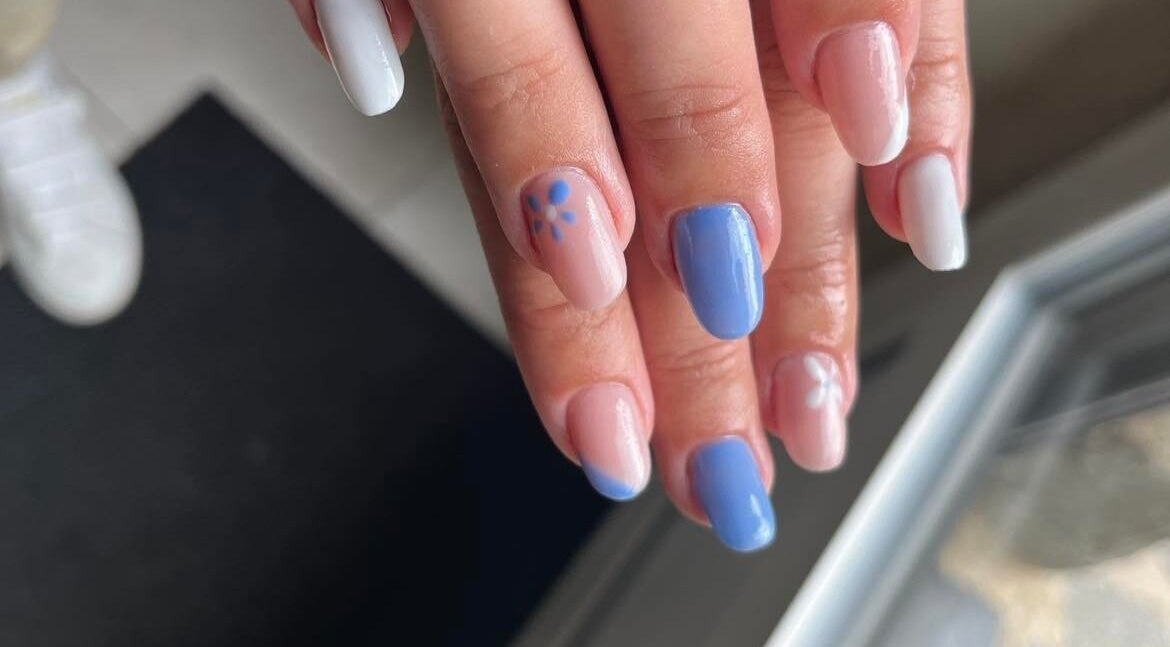 Une manucure pastel à Les Douces Heures De Marie, Ruffiac, Bretagne, FR avec des motifs floraux blancs et bleus.