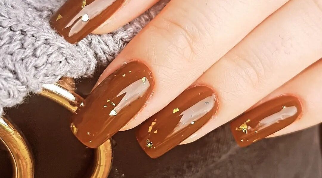 Manucure élégante avec vernis brun et paillettes à Les Douces Heures De Marie, Ruffiac, Bretagne, FR.