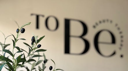 Planta de olivo frente al logo de To Be Beauty Therapy en Mazatlán, Sinaloa, MX.