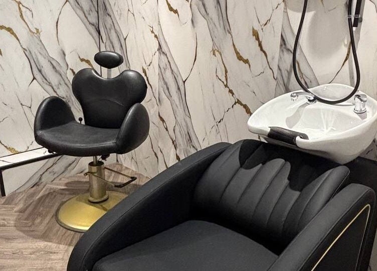 Luxurious salon chair and wash basin at MUSE, Greenock, Scotland, GB with marble wall.