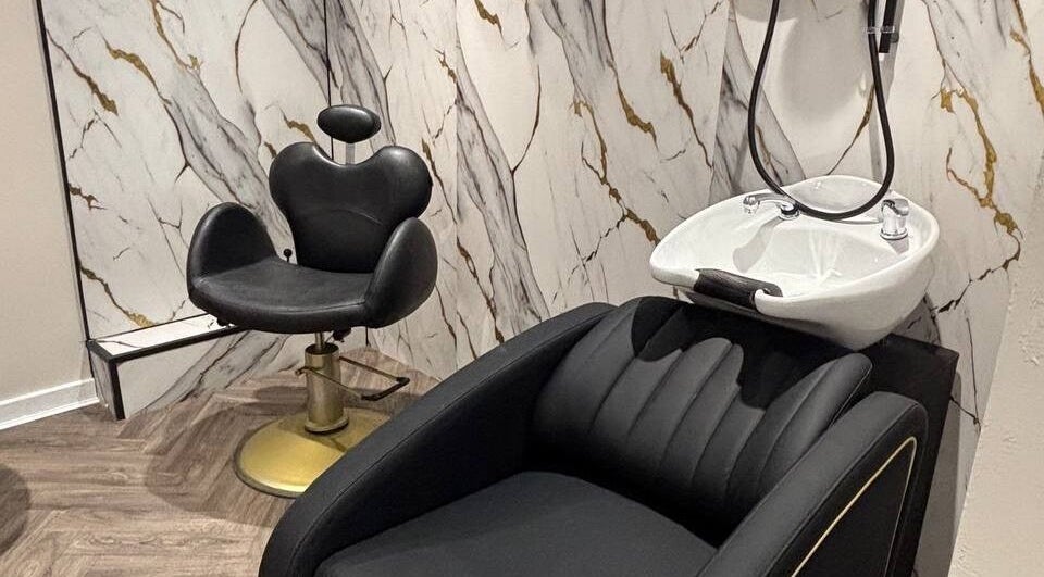Luxurious salon chair and wash basin at MUSE, Greenock, Scotland, GB with marble wall.
