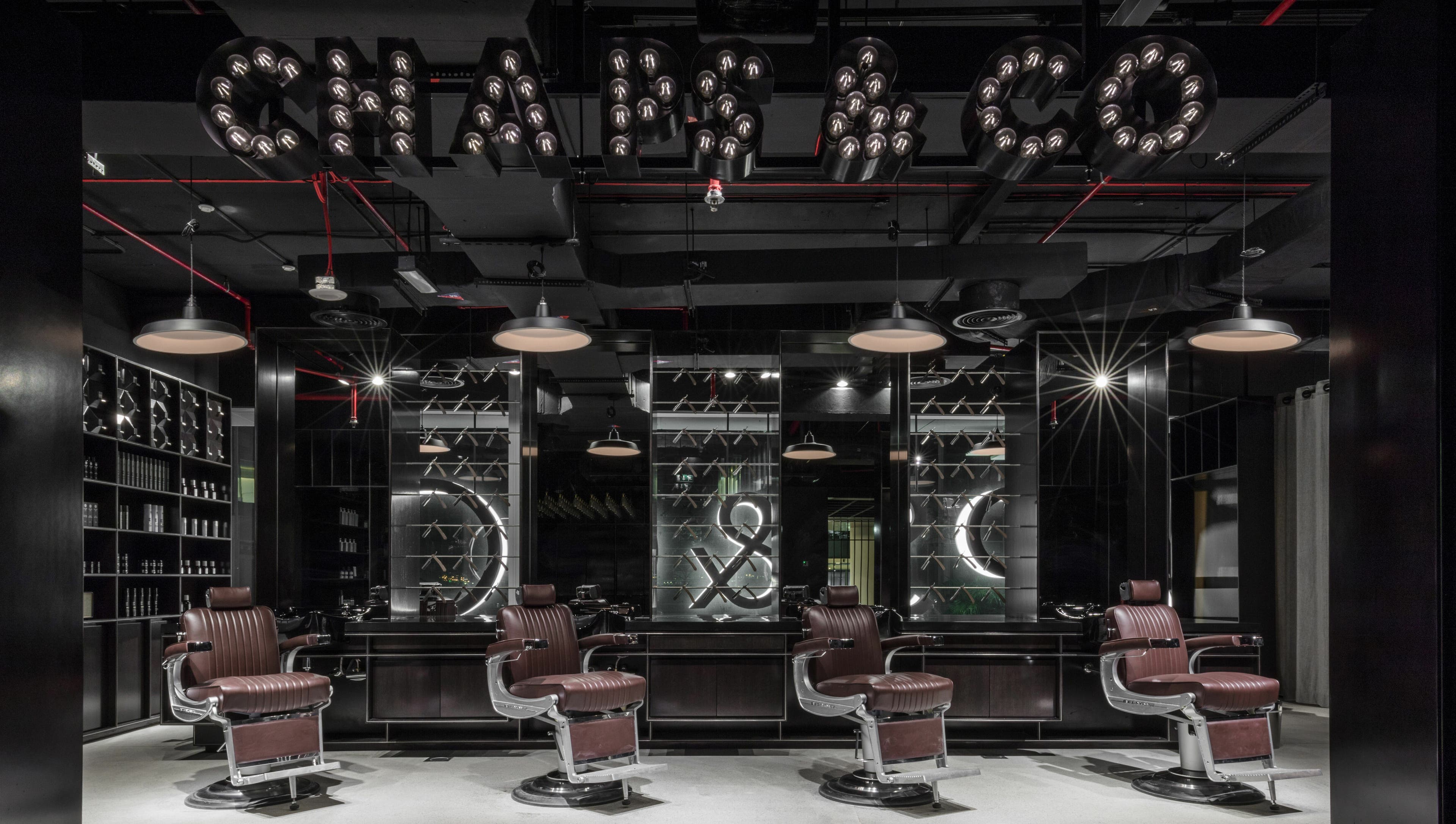 Stylish interior of Chaps & Co Dubai Design District D3 barber shop, Dubai, AE with plush chairs and modern decor.