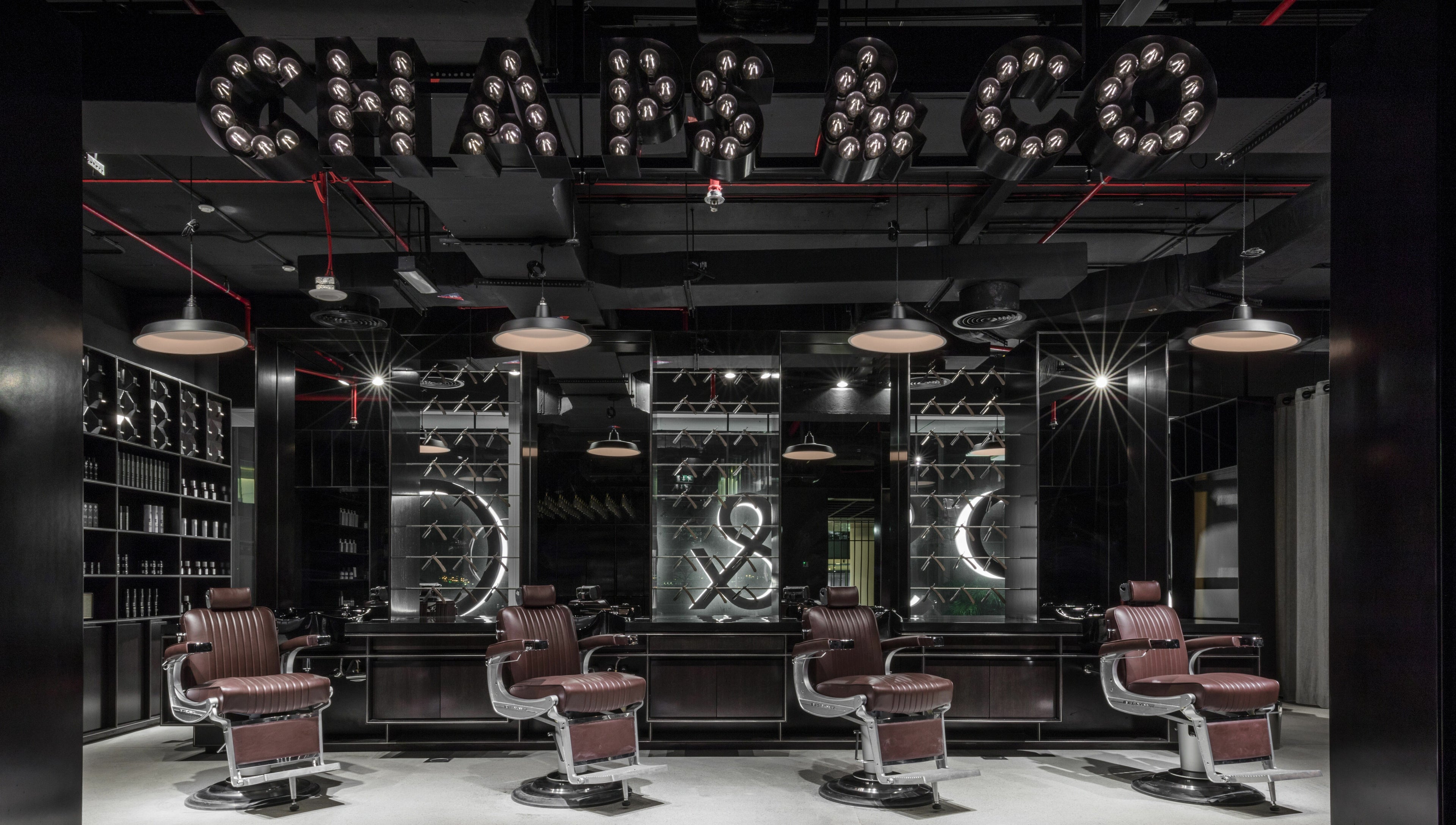 Stylish interior of Chaps & Co Dubai Design District D3 barber shop, Dubai, AE with plush chairs and modern decor.