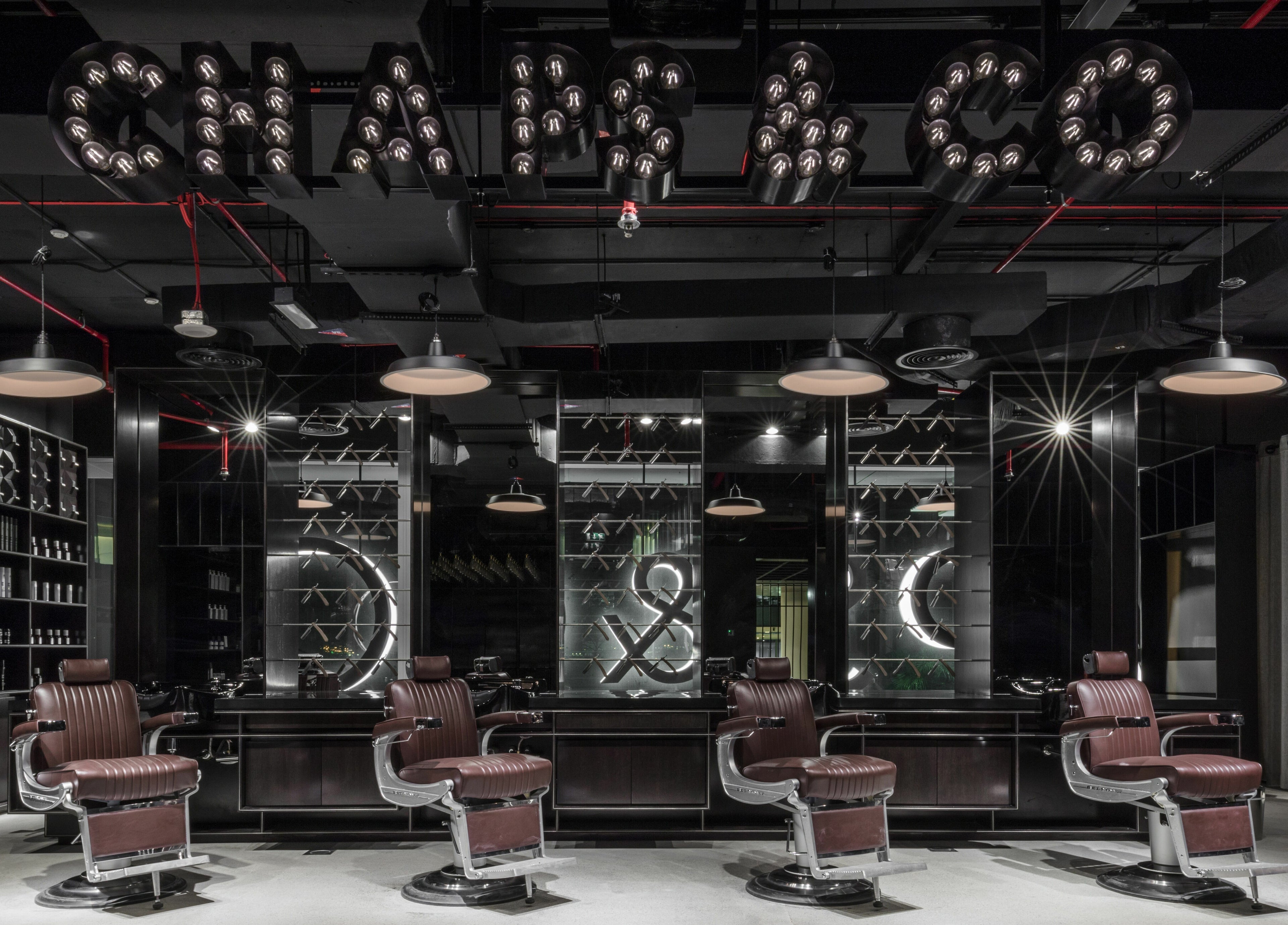 Stylish interior of Chaps & Co Dubai Design District D3 barber shop, Dubai, AE with plush chairs and modern decor.