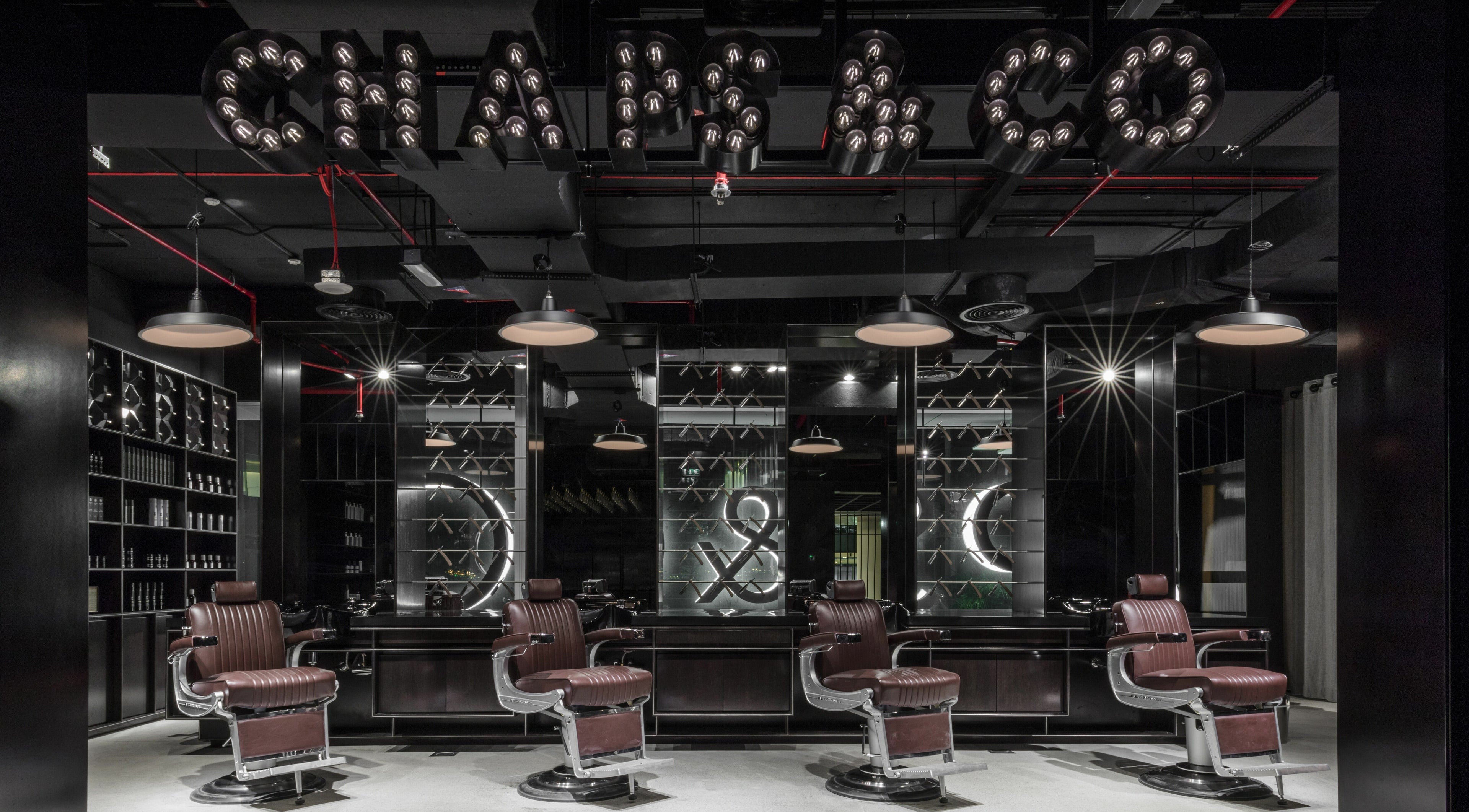 Stylish interior of Chaps & Co Dubai Design District D3 barber shop, Dubai, AE with plush chairs and modern decor.