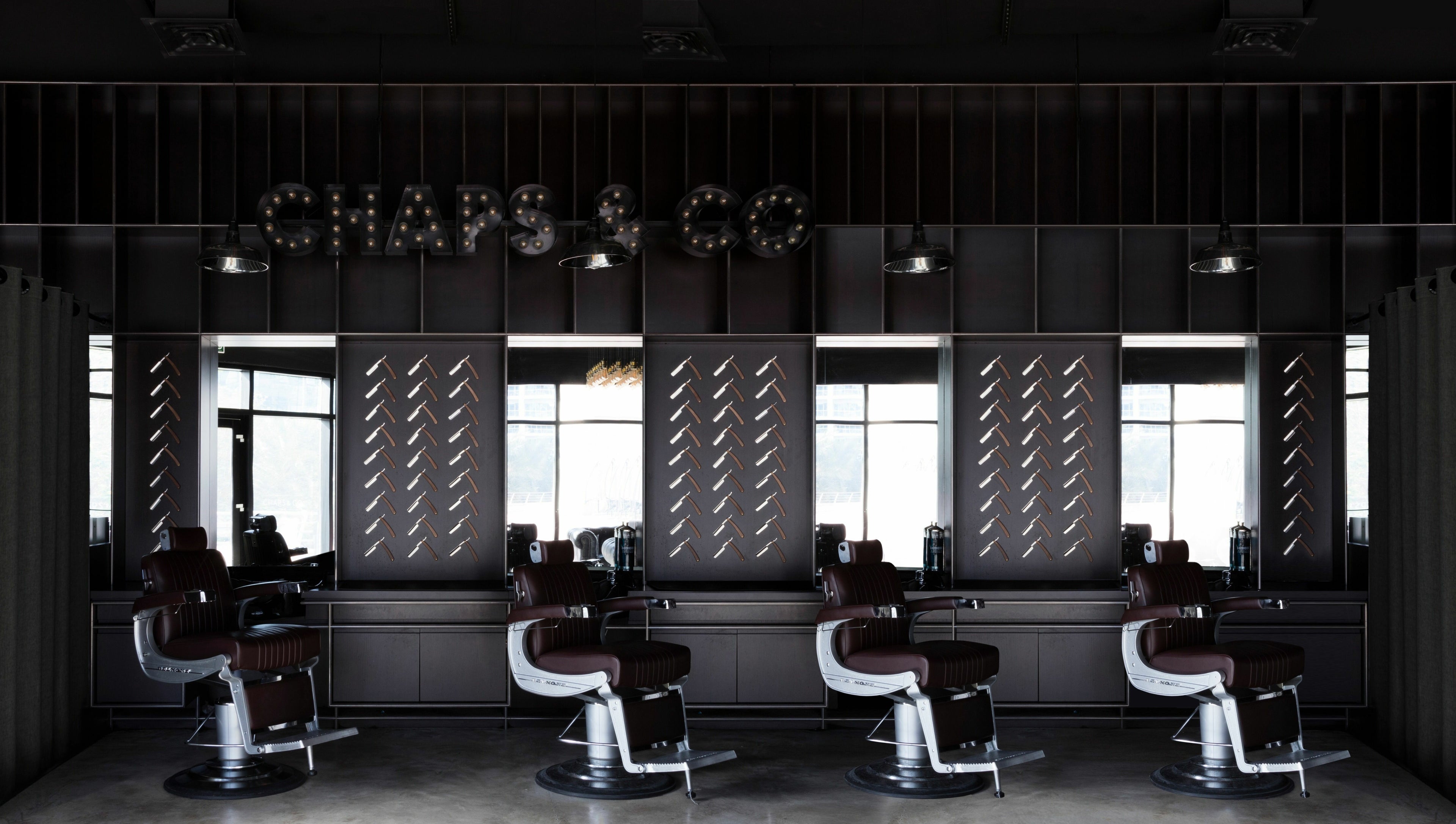 Interior of Chaps & Co - JLT barber shop in Dubai, AE with sleek chairs and modern decor.