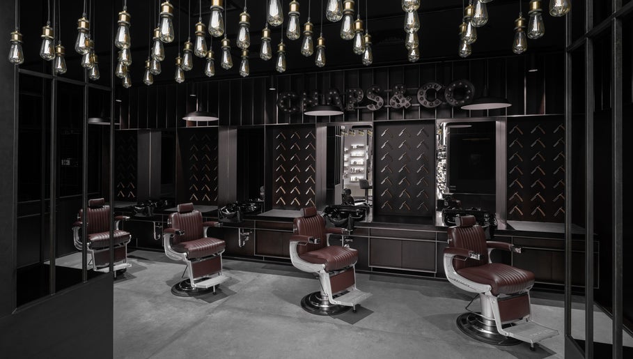 Elegant interior of Chaps & Co - Bloomingdale's in Dubai, Dubai, AE featuring luxurious barber chairs.