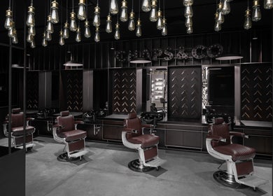 Elegant interior of Chaps & Co - Bloomingdale's in Dubai, Dubai, AE featuring luxurious barber chairs.