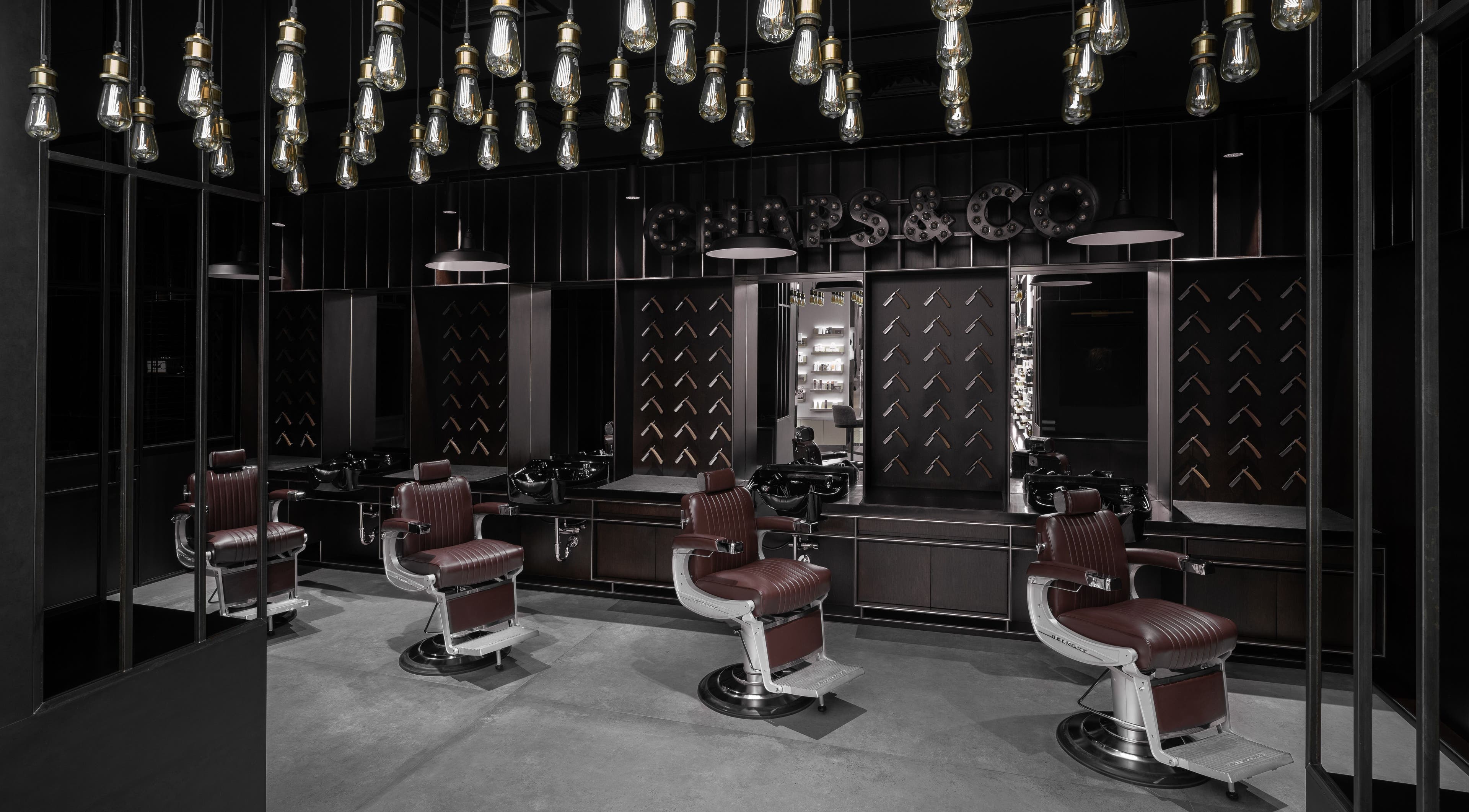 Elegant interior of Chaps & Co - Bloomingdale's in Dubai, Dubai, AE featuring luxurious barber chairs.