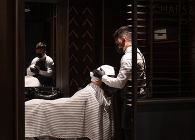 A barber at Chaps & Co - Bloomingdale's, Dubai, Dubai, AE, offering a grooming service.