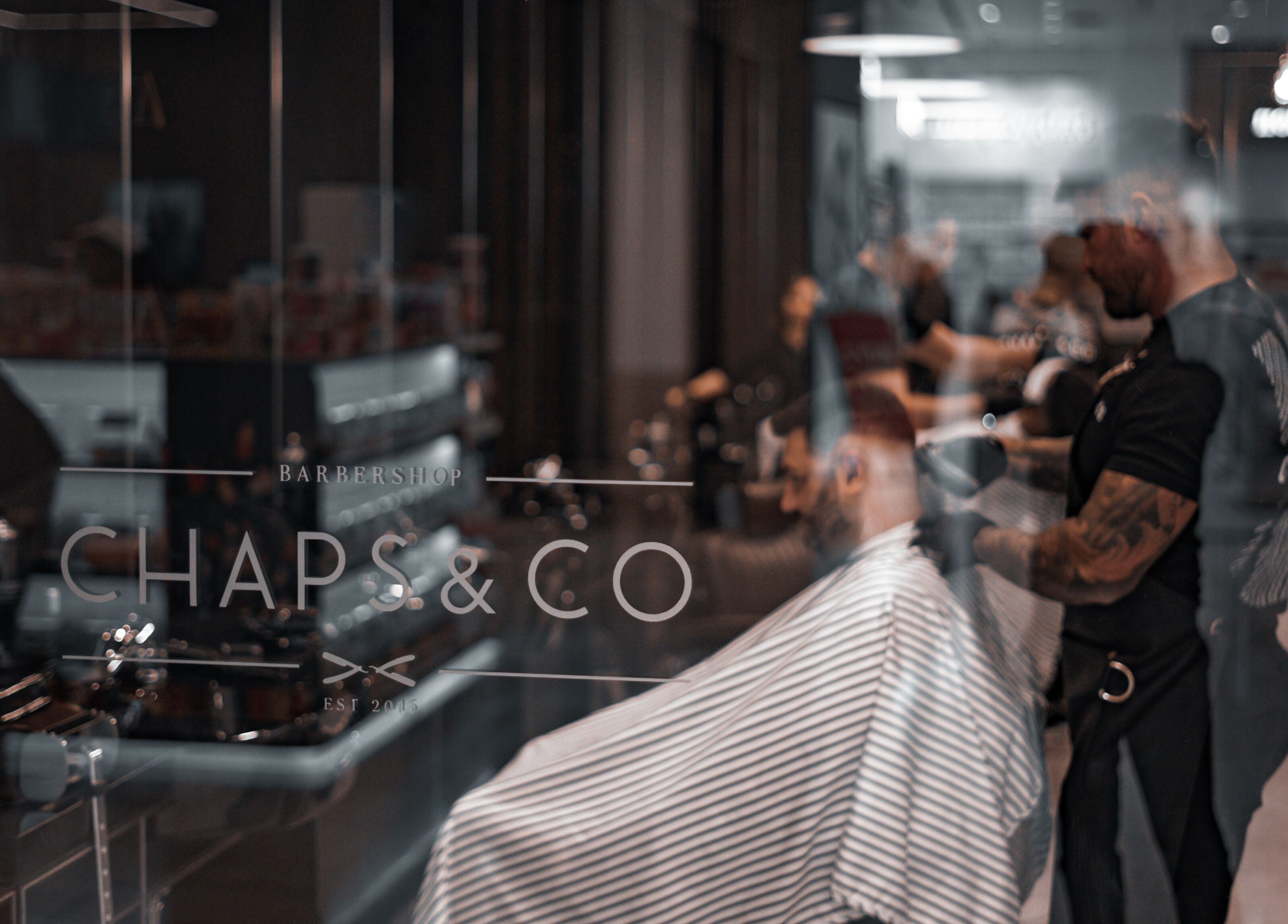 Interior view of Chaps & Co Yas Mall, Abu Dhabi, showcasing sleek barbershop design.