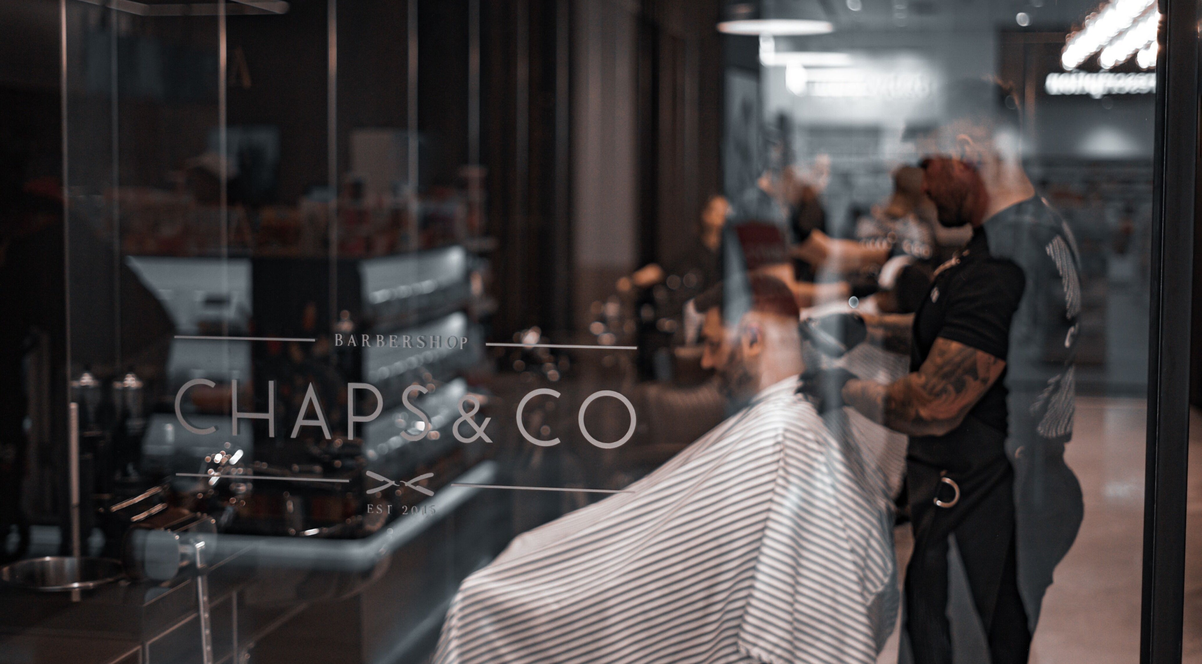 Interior view of Chaps & Co Yas Mall, Abu Dhabi, showcasing sleek barbershop design.