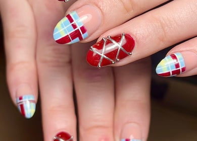 Colorful plaid nail art design at Beauty By Phoebs, Reigate, England, GB, featuring red and blue patterns.
