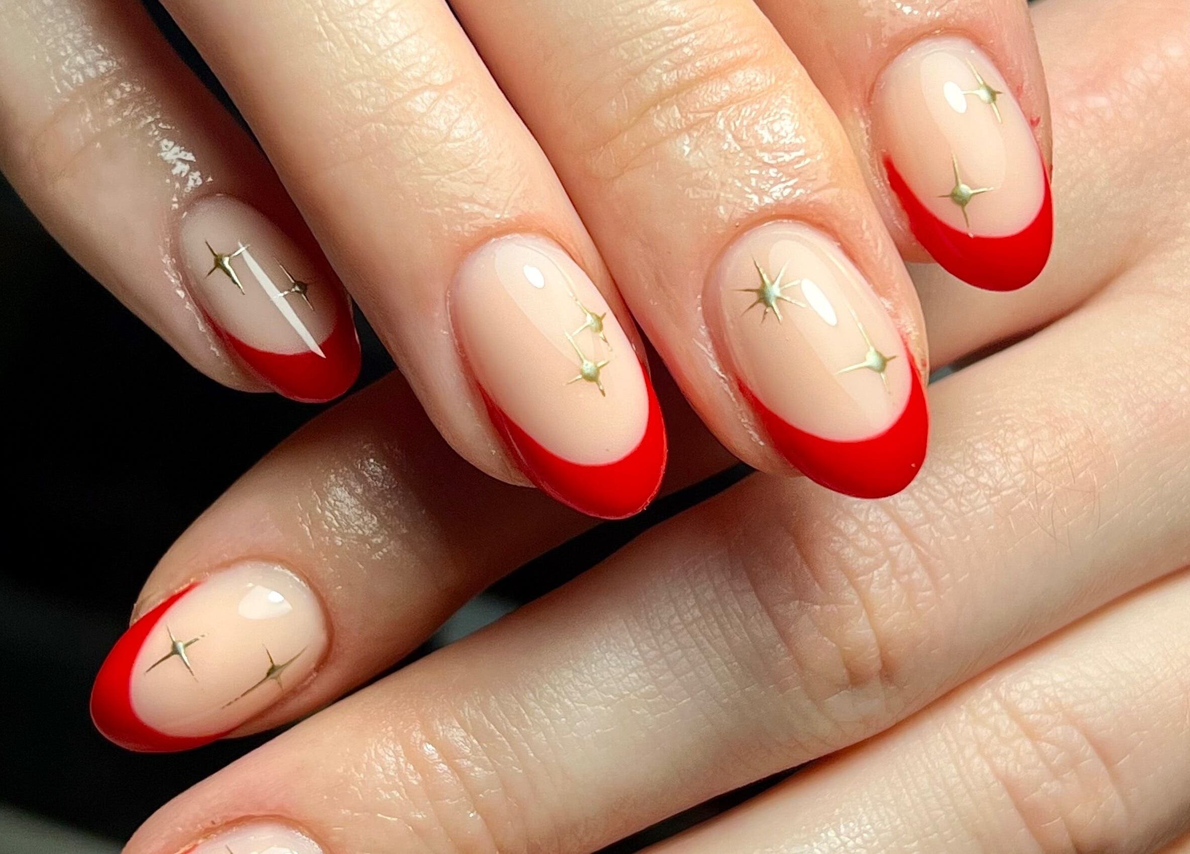 Stylish red-tipped nails with gold accents at Beauty By Phoebs - Hackney, London, England, GB.