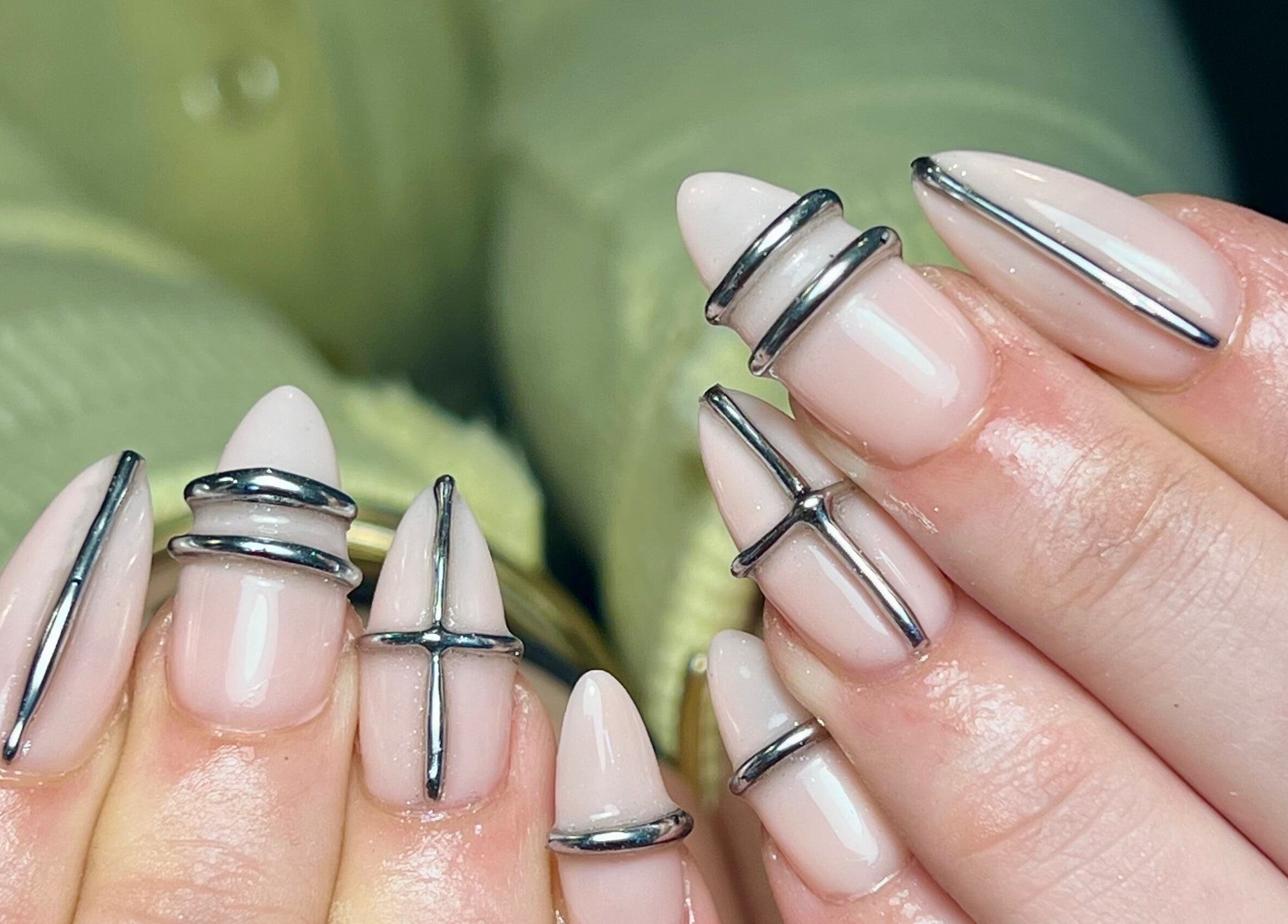 Unique metal nail art at Beauty By Phoebs - Hackney, London, England, GB. Trendy design with silver accents.