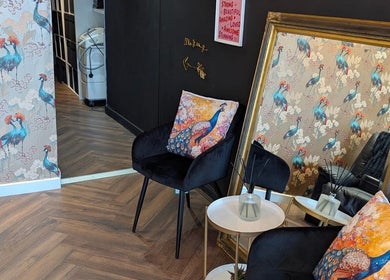 Stylish lounge area at Victoria Jane Makeup, Glasgow, Scotland, GB with peacock decor and elegant mirror.