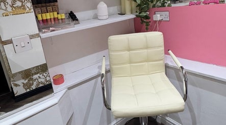 Comfortable makeup chair in Victoria Jane Makeup, Glasgow, Scotland, GB with beauty products on shelf.