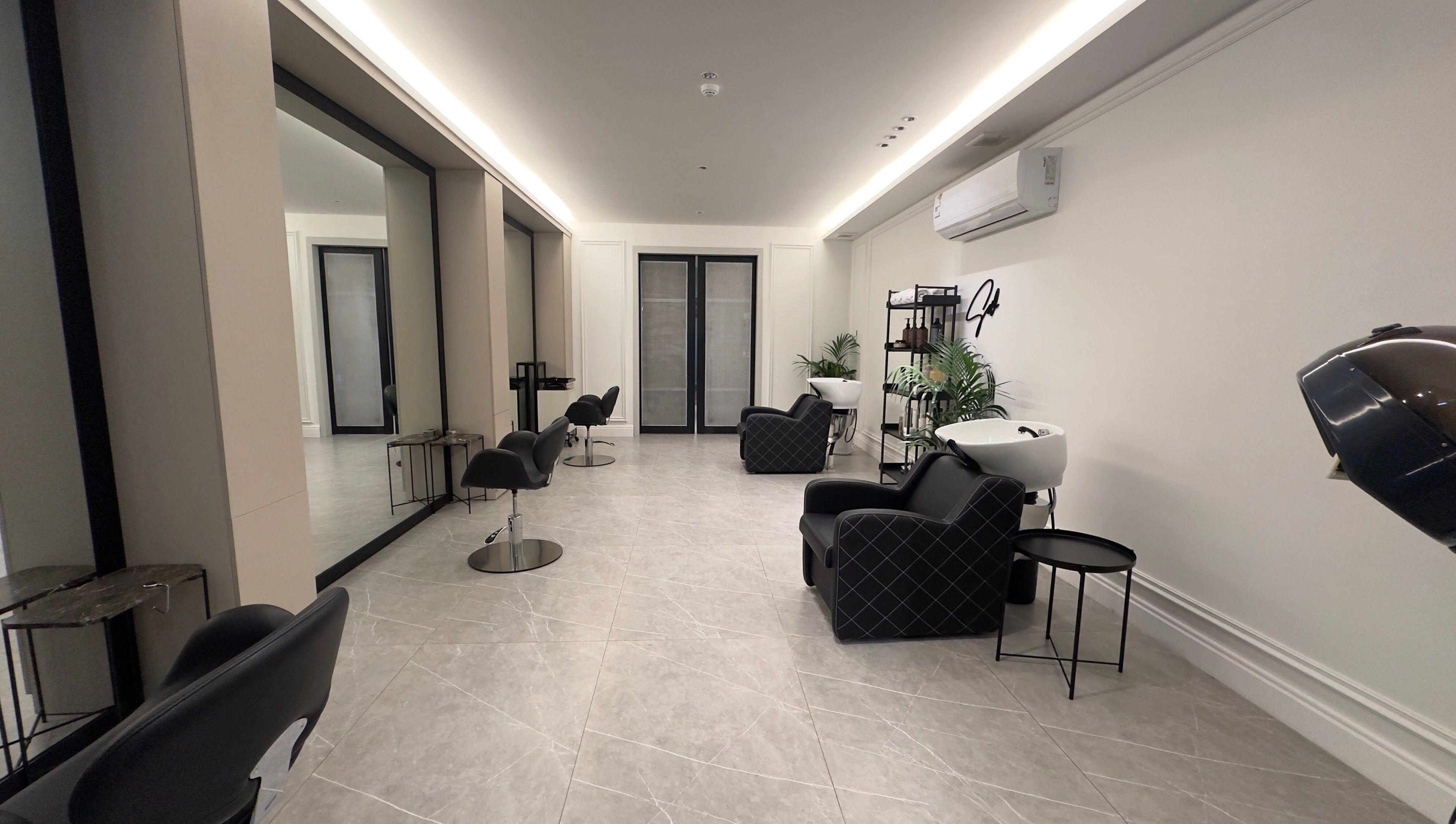 Modern salon interior at Sw Salon, Riyadh, Riyadh Province, SA, featuring chic black chairs and mirrors.