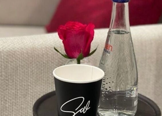 Elegant refreshment setup at Sw Salon, Riyadh, Riyadh Province, SA with a rose, water bottle and cup.