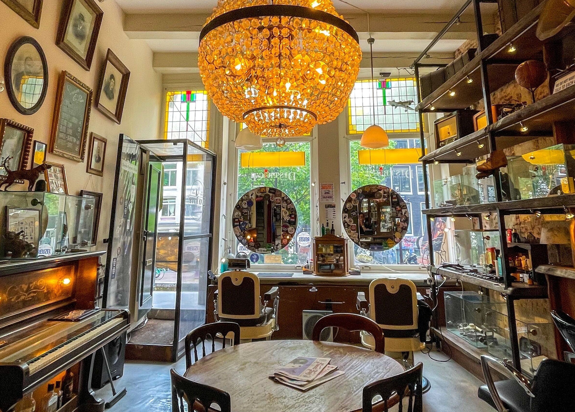 Chic interior of Cutting Casper, Amsterdam, Noord-Holland, NL, featuring vintage decor and elegant chandeliers.