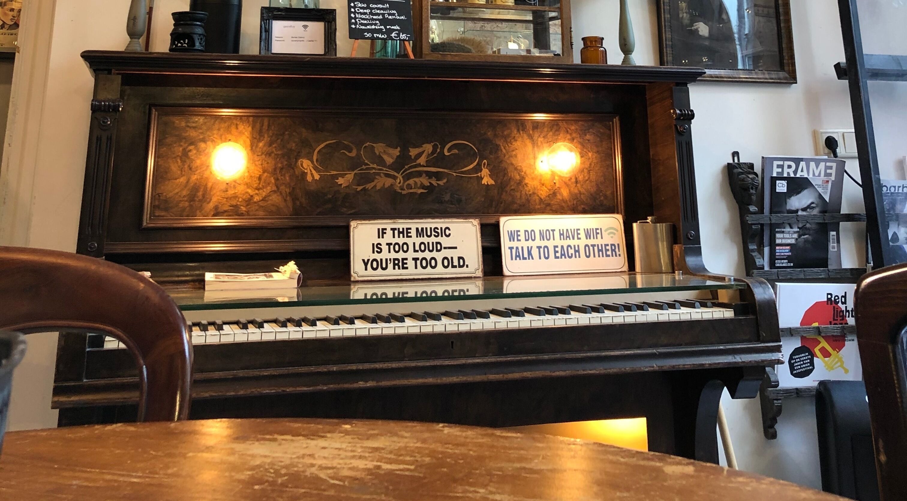 Cozy vintage piano inside Cutting Casper, Amsterdam, Noord-Holland, NL, creating a warm ambiance.