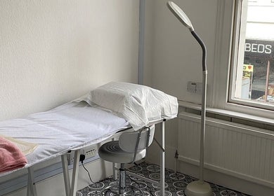 Serene therapy room at iBeautify, Royal Tunbridge Wells, GB, featuring a treatment bed and lamp.