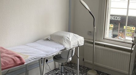Serene therapy room at iBeautify, Royal Tunbridge Wells, GB, featuring a treatment bed and lamp.