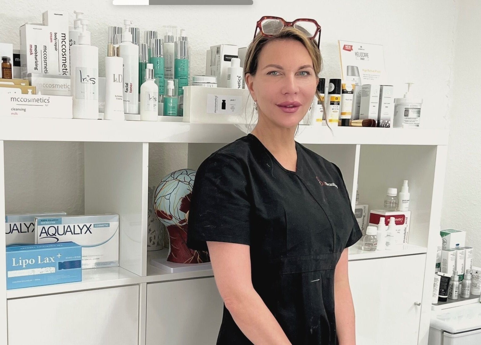 Professional beauty expert at I Beautify, Royal Tunbridge Wells, GB, with skincare products.