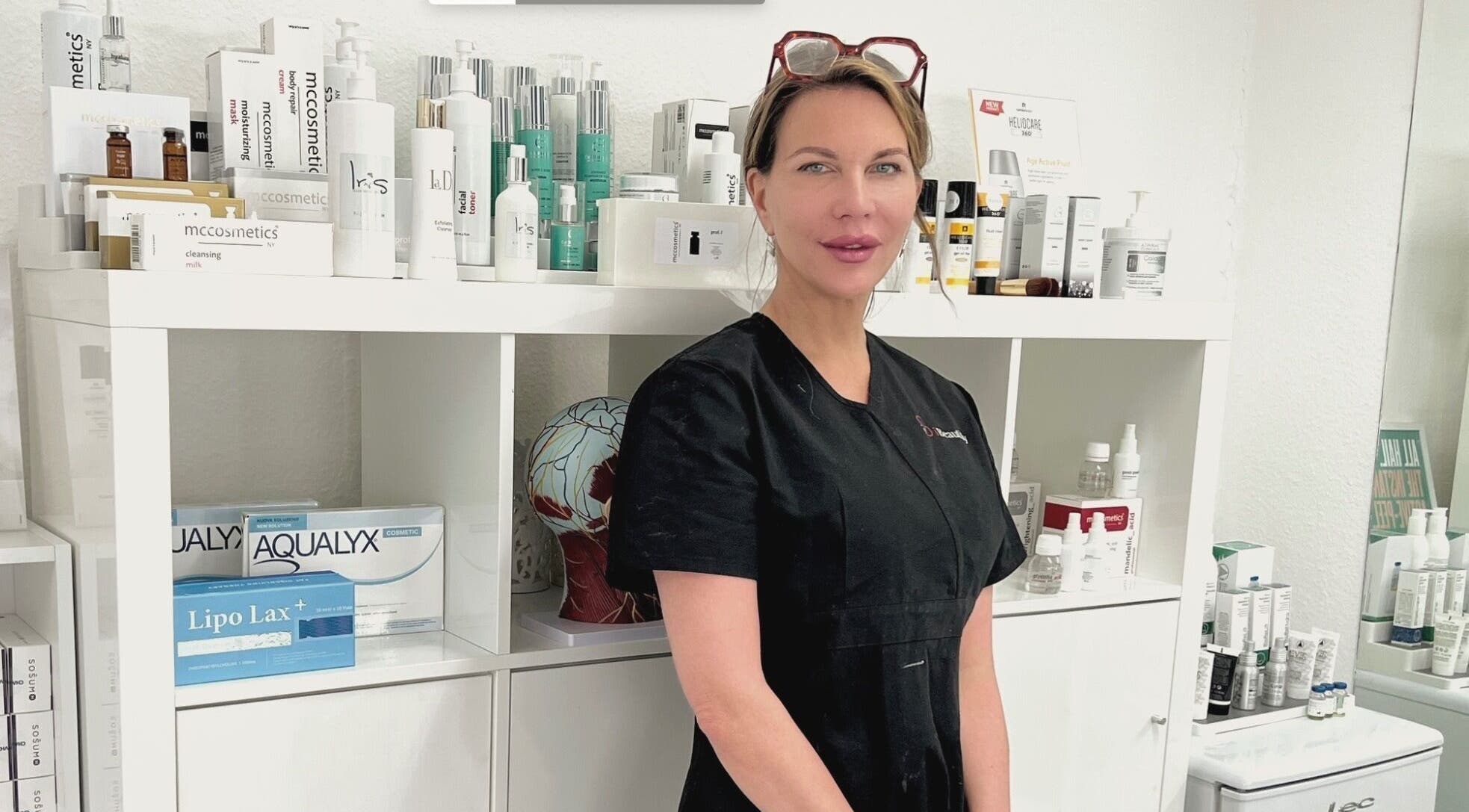 Professional beauty expert at I Beautify, Royal Tunbridge Wells, GB, with skincare products.