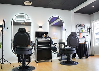 Sleek interior of Dogan Barbershop in Stavanger, Rogaland, NO, featuring stylish chairs and bright mirrors.