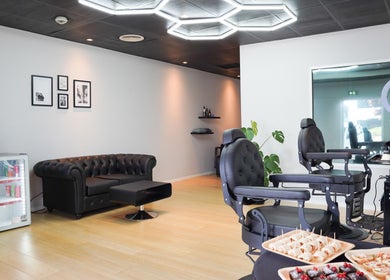 Dogan Barbershop in Stavanger, Rogaland, NO, features modern chairs, stylish decor, and refreshments for clients.