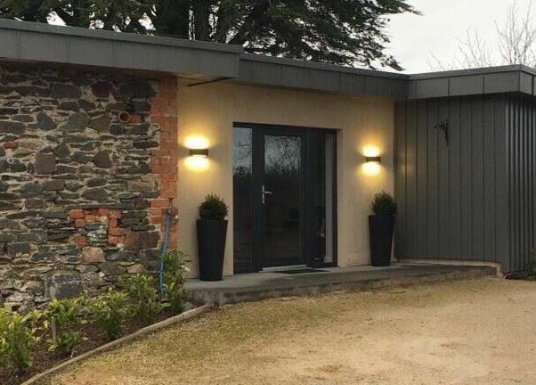Entrance of BeYOUtifi, Donaghadee, Northern Ireland, GB, featuring modern lighting and stone wall.