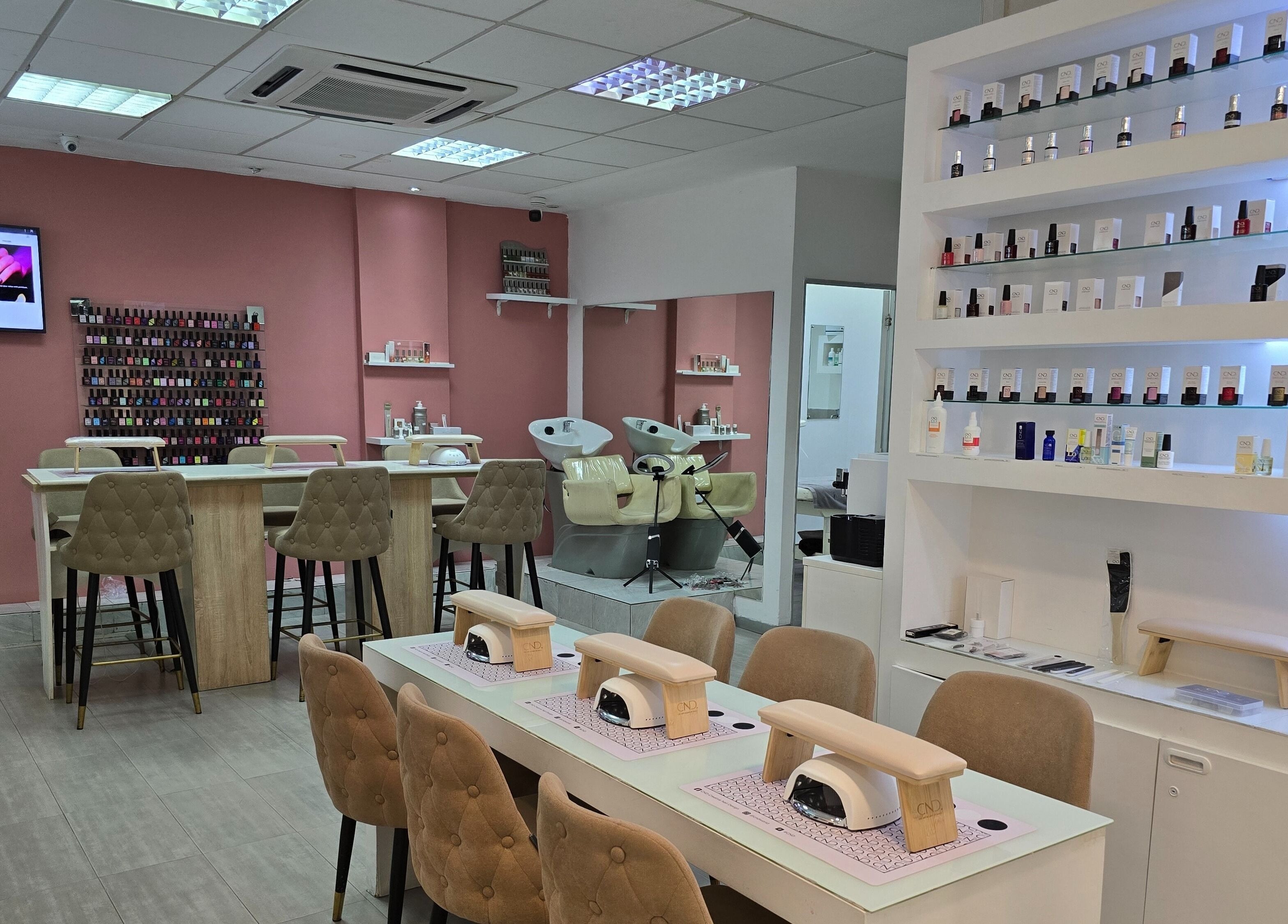 Intérieur moderne de Mynails Spa LTD à Port Louis, avec stations de manucure et présentoirs de vernis.