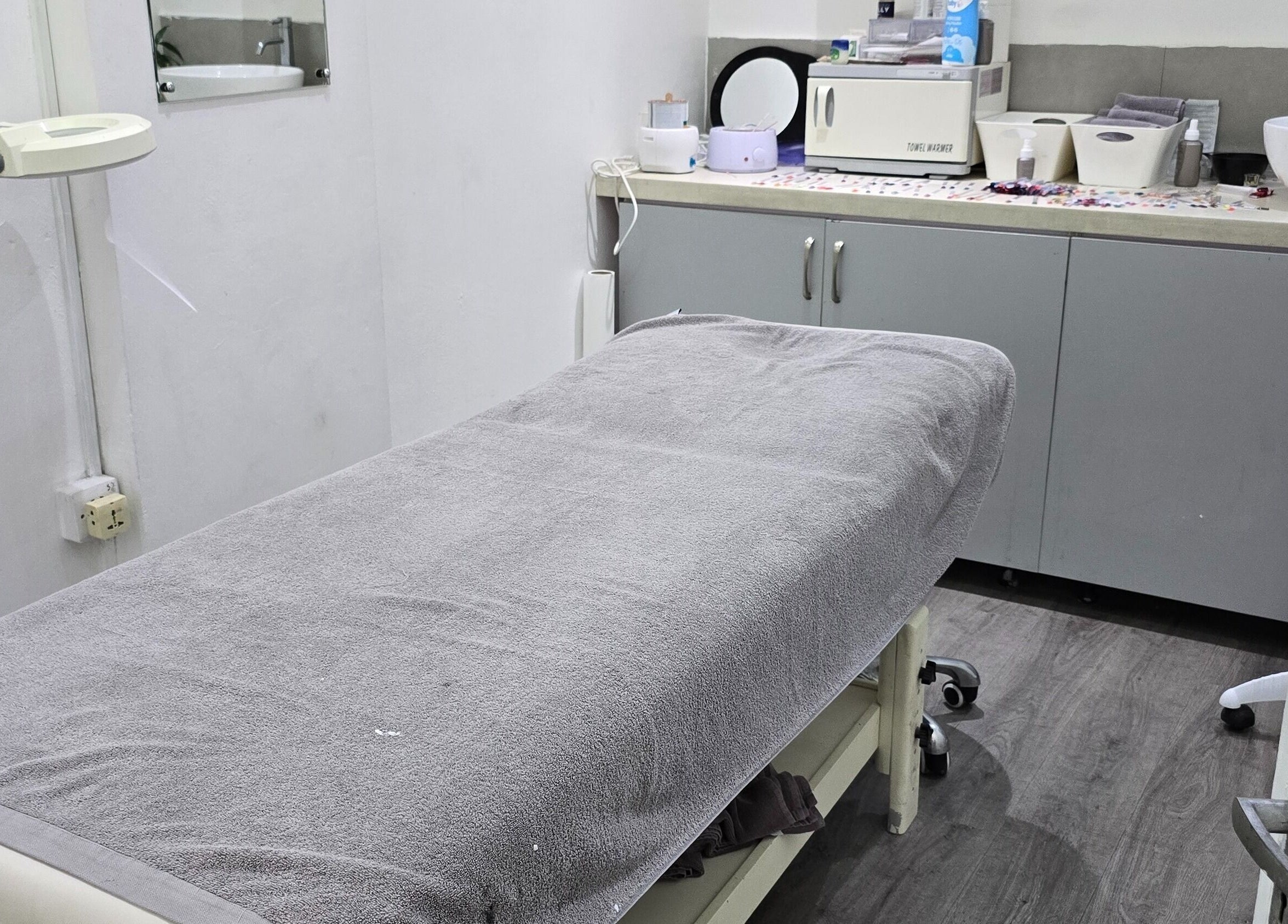 Salle de soins relaxante à Mynails Spa LTD, Port Louis, Port Louis District, MU, avec table de massage grise.