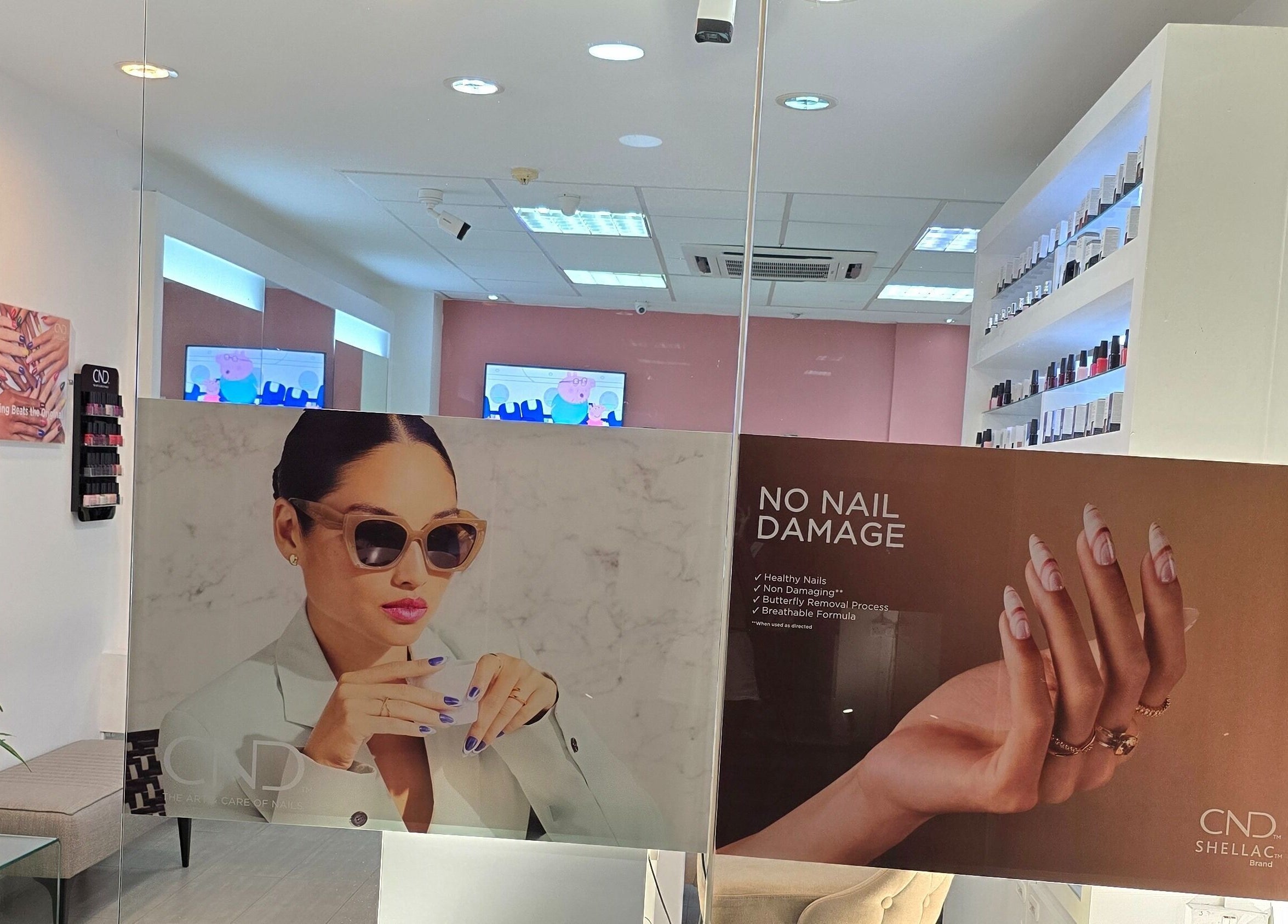 Intérieur moderne de Mynails Spa LTD, Port Louis, avec affiches de soins ongles et rangement de vernis.
