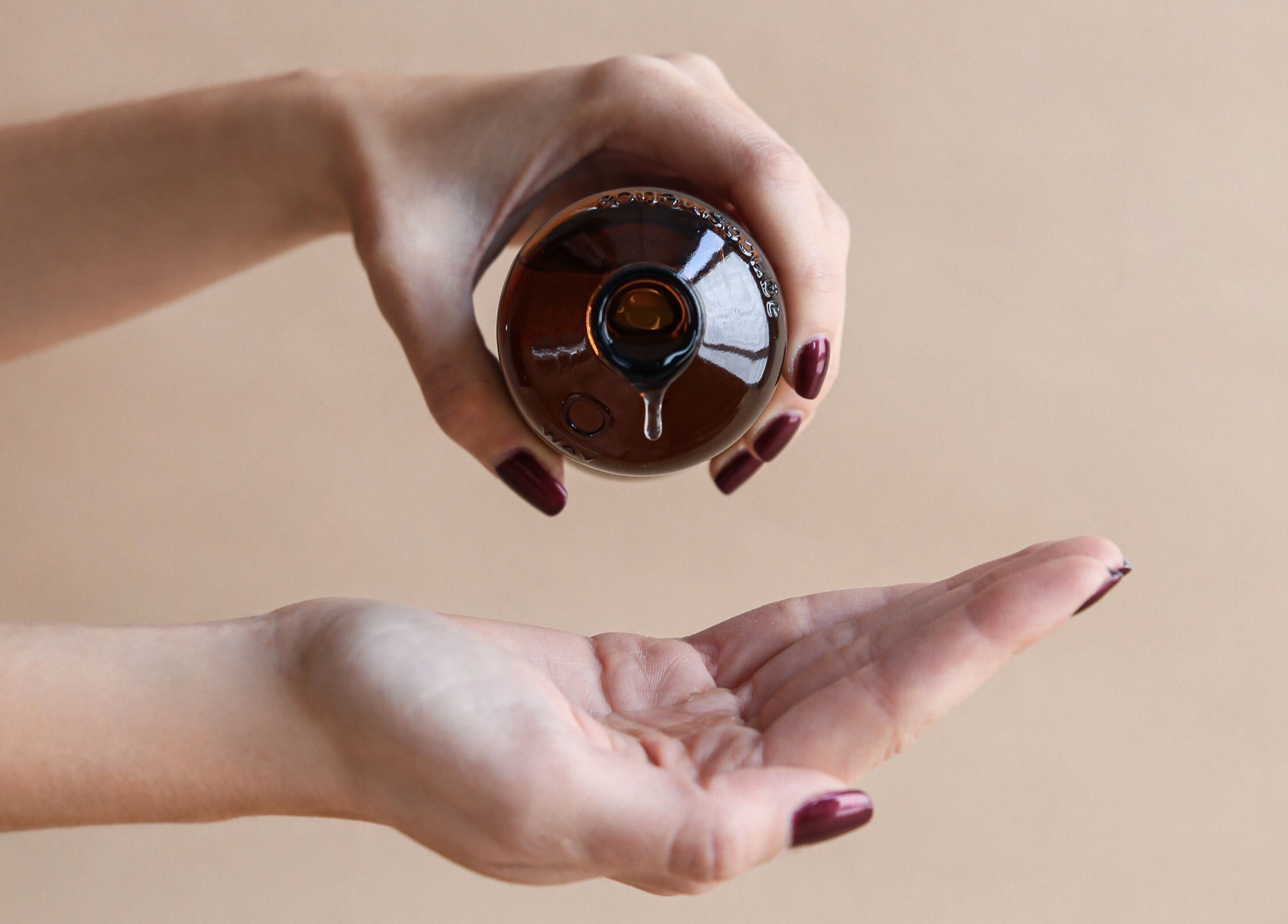 Hands pouring oil at Esthetique Head Spa Weybridge, Weybridge, England, GB for relaxation.