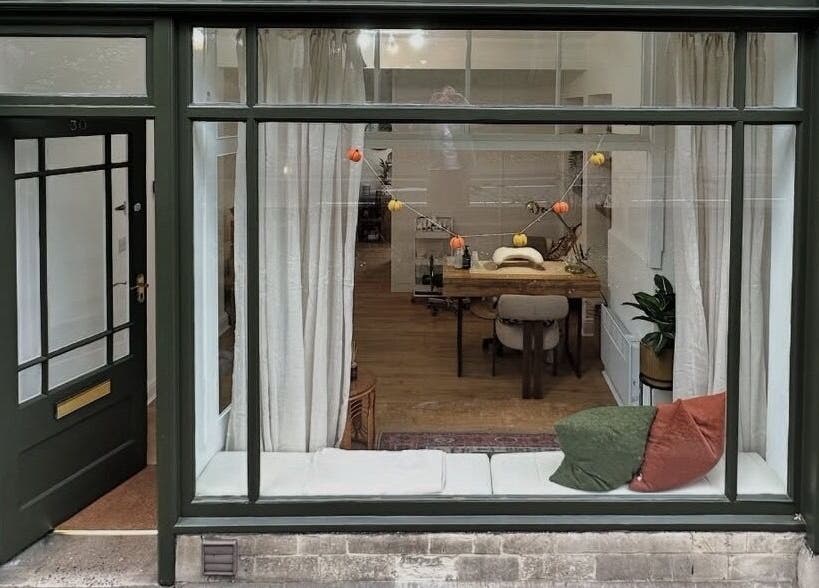 Chic storefront of Skin by Fran, Bath, England, GB, showcasing cozy interior and large window display.