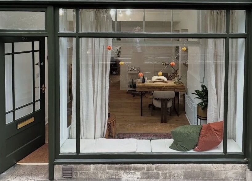 Chic storefront of Skin by Fran, Bath, England, GB, showcasing cozy interior and large window display.