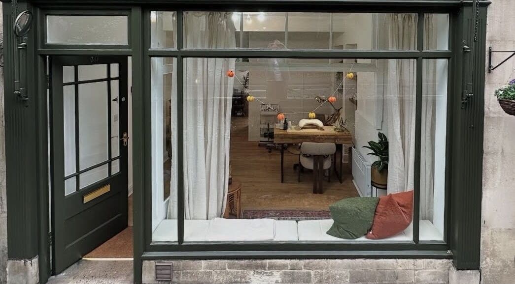 Chic storefront of Skin by Fran, Bath, England, GB, showcasing cozy interior and large window display.